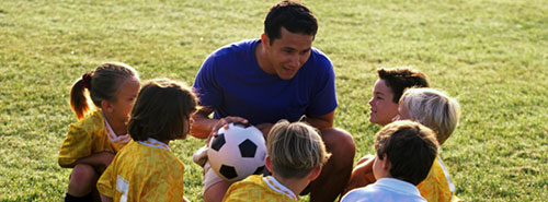 Fussballtrainer mit Kindern